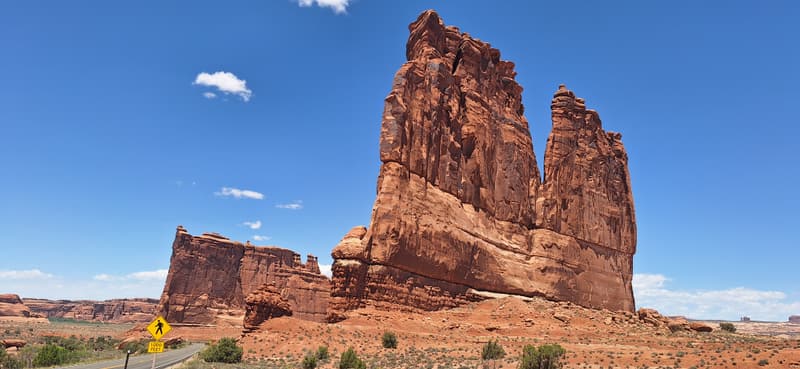 Tall sandstone towers standing above desert scrub under a clear blue sky.